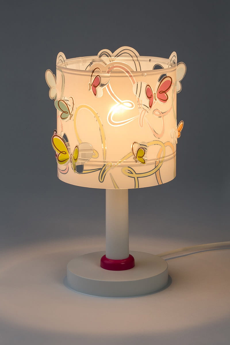 Lampka nocna Butterfly z białym kloszem ozdobionym kolorowymi motylkami w odcieniach różu, żółci i zieleni. Stojąca na okrągłej, białej podstawie z różowym akcentem. Widok frontalny, podkreślający detale dekoracyjne klosza.