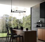 Lampa wisząca Ring MOD013PL-06B w kolorze czarnym, z sześcioma okrągłymi kloszami w białym kolorze. Zawieszona nad drewnianym stołem w nowoczesnej kuchni, z widokiem na zieleń za oknem. Klosze równomiernie rozmieszczone na okrągłej konstrukcji.