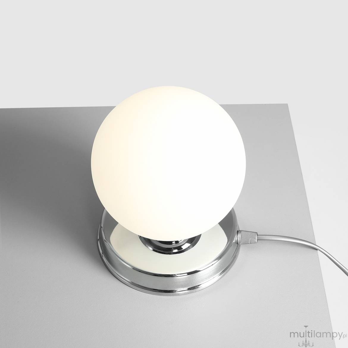 Lampa stołowa Ball D14 z białą, okrągłą kulą na chromowanej podstawie. Widok z góry, z kablem zasilającym. Prosta, elegancka forma idealna do nowoczesnych wnętrz.