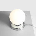 Lampa stołowa Ball D14 z białą, okrągłą kulą na chromowanej podstawie. Widok z góry, z kablem zasilającym. Prosta, elegancka forma idealna do nowoczesnych wnętrz.