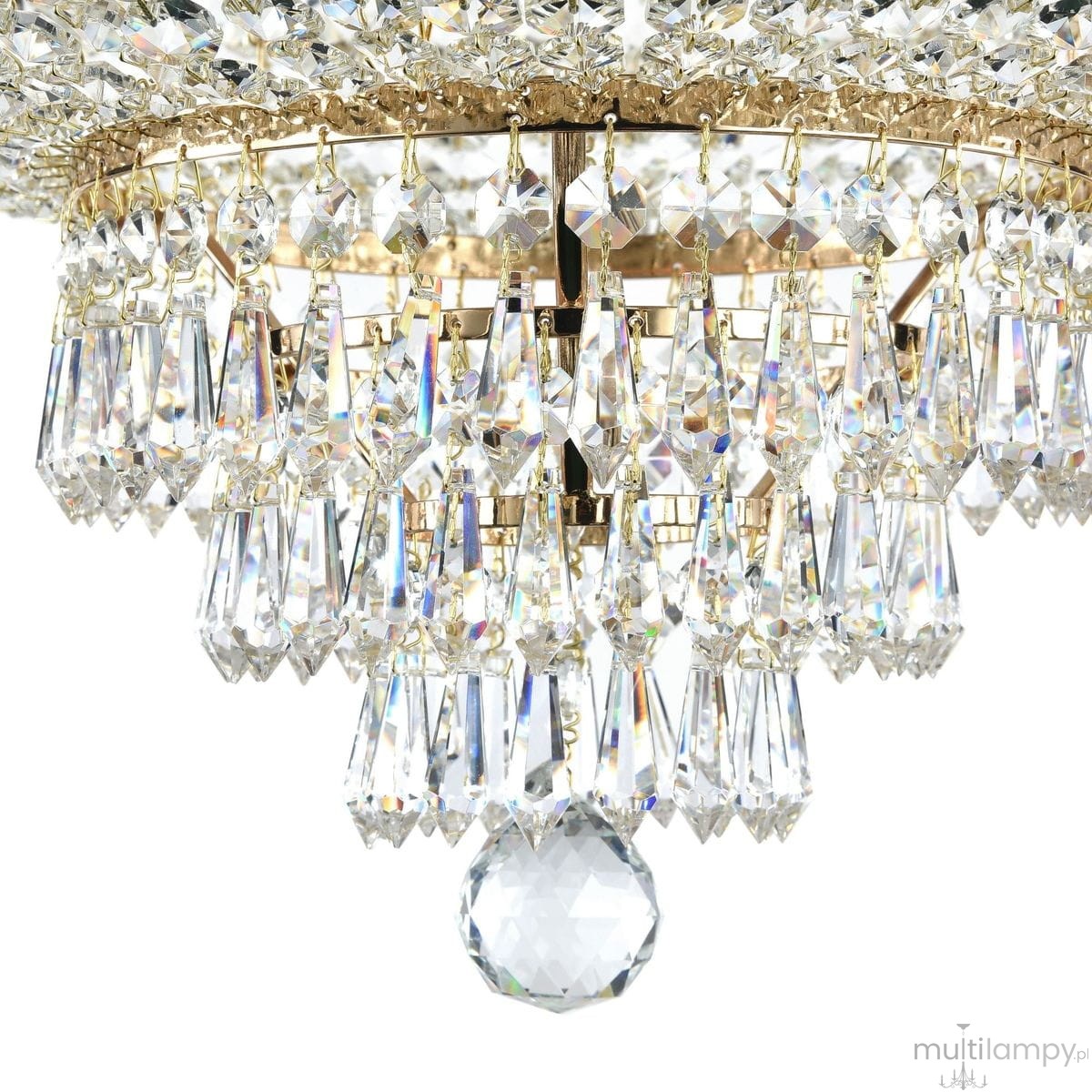 Lampa sufitowa Palace 18-punktowa, złota konstrukcja z kryształowymi zwisami. Widoczne długie, przezroczyste kryształy w kształcie łez oraz centralny, okrągły kryształ. Ujęcie z boku ukazujące detale i blask lampy na białym tle.