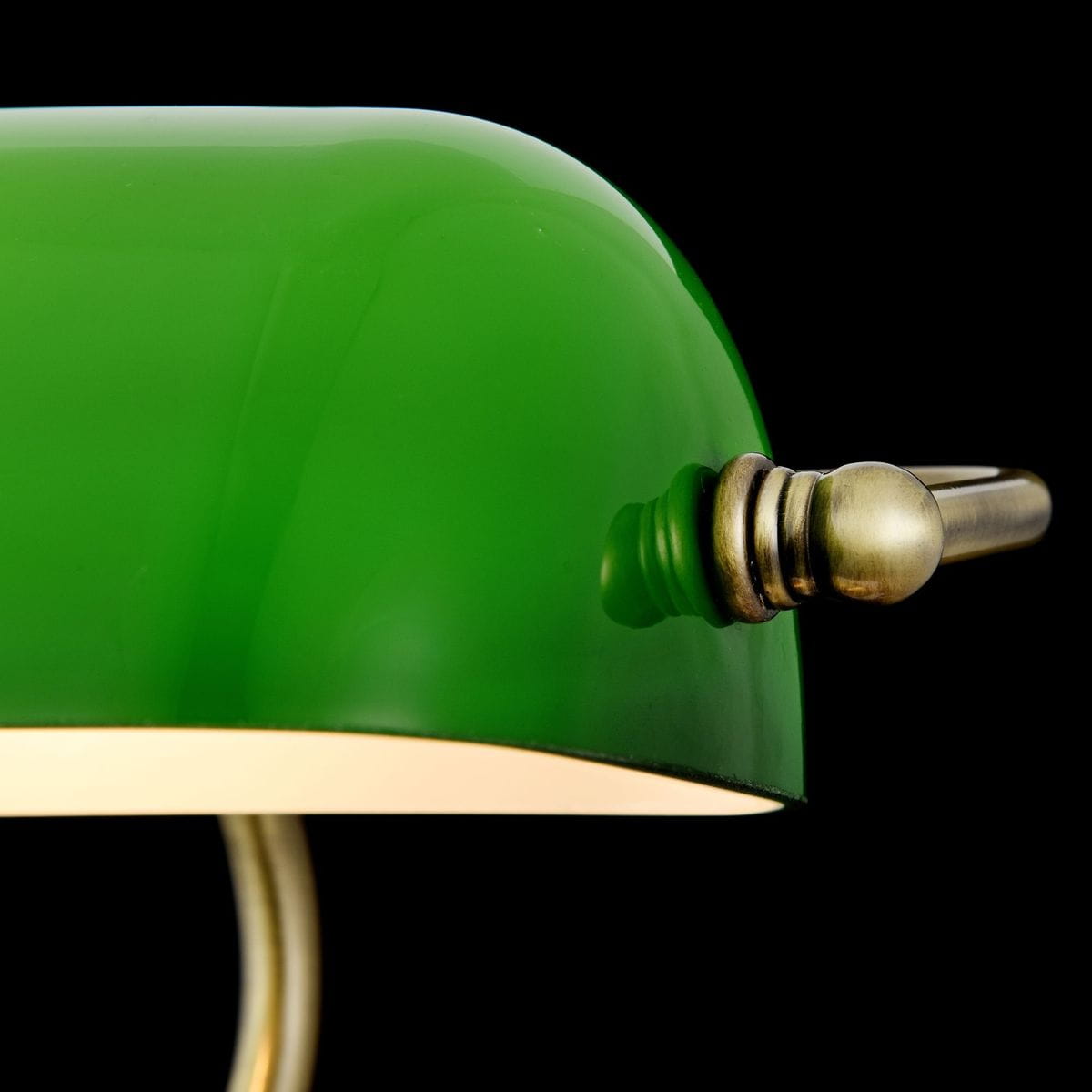 Lampka stołowa Kiwi Z153-TL-01-BS z zielonym kloszem z przezroczystego szkła, metalową podstawą w kolorze mosiądzu i regulatorem. Klosz ma zaokrąglony kształt, a całość prezentuje się na czarnym tle.