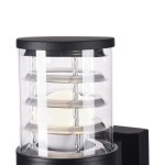 Kinkiet zewnętrzny Bronx O576WL-01B w czarnej obudowie z przezroczystym kloszem. Widoczne metalowe elementy w formie pierścieni, okrągłe źródło światła wewnątrz. Produkt umieszczony w pozycji stojącej, zbliżenie na detal konstrukcji.