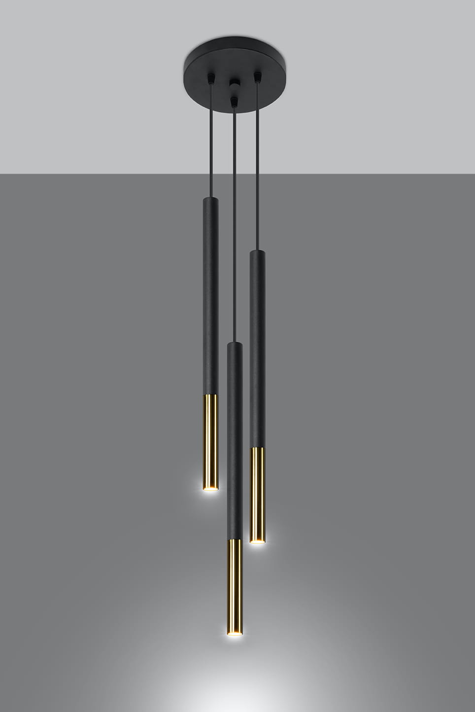 Lampa wisząca Mozaica 3-punktowa w kolorze czarnym i złotym, składająca się z trzech prostokątnych, wiszących elementów. Kąt ujęcia frontalny, ukazuje detale wykończenia oraz jasno świecące końcówki.