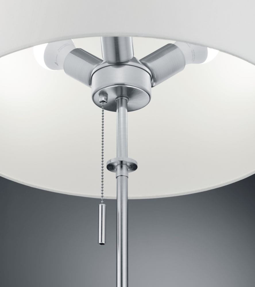 Lampa podłogowa Lyon 3-punktowa w kolorze niklu. Metalowa konstrukcja z białym kloszem, z widocznymi źródłami światła. U góry umieszczony mechanizm z łańcuszkiem do włączania. Ujęcie zbliżeniowe na detal i górną część lampy.