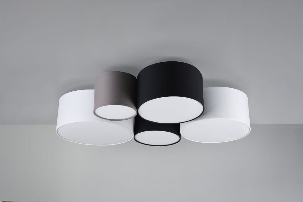 Lampa sufitowa 5-punktowa w kolorach białym, czarnym i szarym, o okrągłych kloszach. Elementy są rozmieszczone asymetrycznie na jasnym tle. Lampa zamontowana na suficie, z widoczną strukturą materiału kloszy.