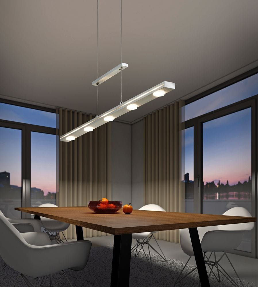 Lacal LED lampa wisząca 7-punktowa w kolorze niklowym, zawieszona nad drewnianym stołem, z sześcioma okrągłymi źródłami światła. Tło z dużymi oknami i zasłonami, tworzy nowoczesny i elegancki klimat w pomieszczeniu.