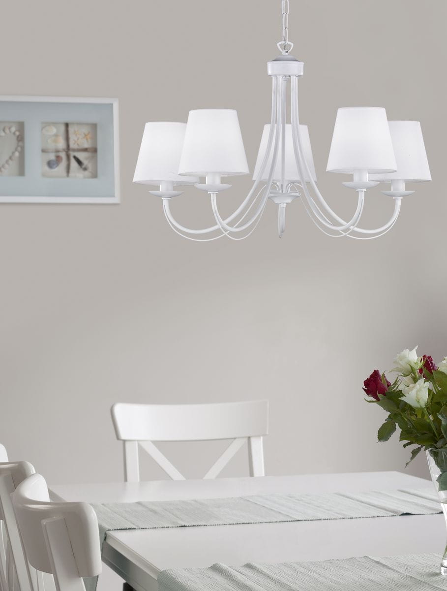 Lampa wisząca Cortez 5-punktowa w kolorze białym. Posiada pięć kloszy w formie stożków, umieszczonych na eleganckich ramionach. Zawieszona na łańcuchu, idealna do aranżacji jadalni. Tło w odcieniach szarości z białymi meblami i bukietem kwiatów.