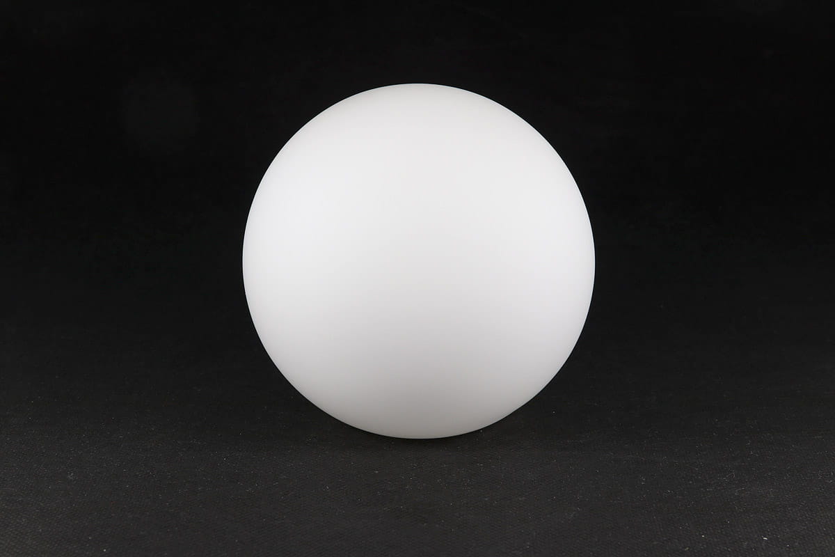Klosz szklany kula o średnicy 140 mm, matowy, w formie idealnej kuli. Ujęcie frontalne, produkt znajduje się na ciemnym tle, co podkreśla jego gładką, białą powierzchnię. Brak widocznych napisów lub logo.