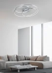 Lampa sufitowa Gale LED 1-punktowa w kolorze niklowym, z nowoczesnym, okrągłym kształtem. Zamontowana na suficie, w jasnym wnętrzu z dużymi oknami. Widziana z dołu, ukazuje dwa splecione pierścienie, emitujące równomierne światło.