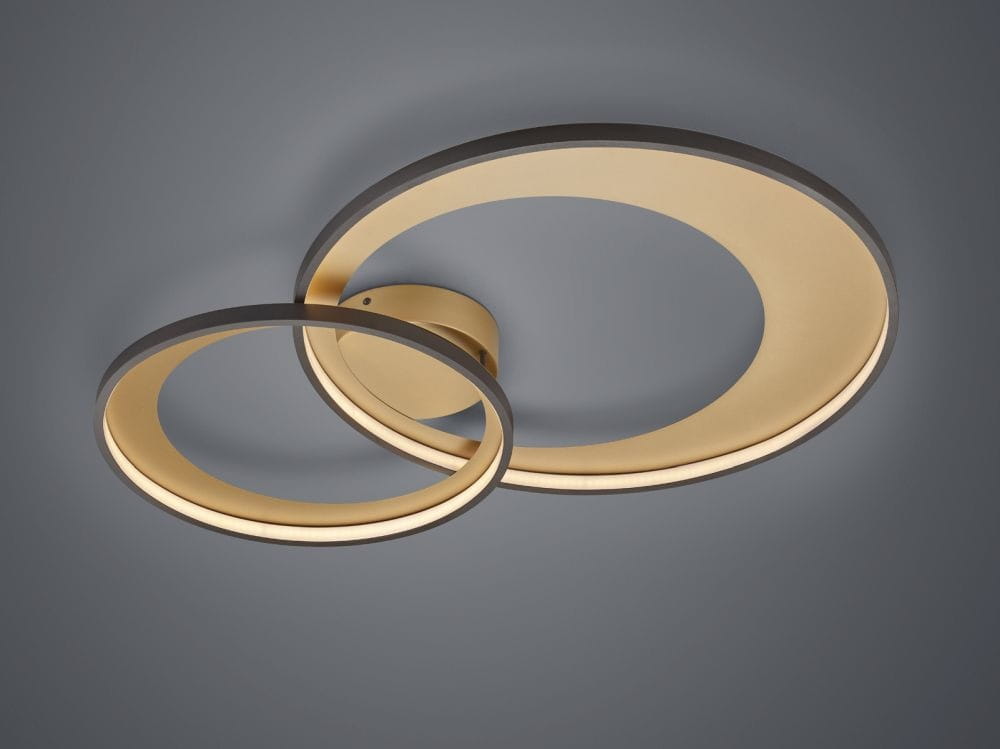 Granada LED lampa sufitowa 2-punktowa w czarno-złotej kolorystyce, złożona z dwóch okrągłych pierścieni o różnej średnicy. Lampa zamontowana na okrągłej podstawie, emituje ciepłe światło. Tło szare, minimalistyczne.