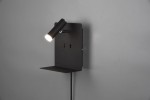 Czarny kinkiet LED z portem USB, zamontowany na ścianie, z regulowanym źródłem światła w formie cylindra. Posiada płaską półkę, na której można umieścić drobne przedmioty. Prosta, nowoczesna konstrukcja na jednolitym tle.
