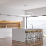 Lampa wisząca Circle LED D78 w kolorze białym, z okrągłym kloszem, zawieszona nad białym blatem kuchennym. Klosz emituje światło, tworząc nowoczesny akcent w jasnym wnętrzu. Widoczna przestrzeń kuchni z drewnianym tłem i barowymi krzesłami.