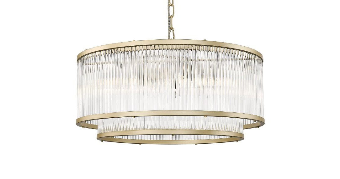 Lampa wisząca Sergio, 6-punktowa, w złotym kolorze. Okrągła konstrukcja z przezroczystymi, pionowymi elementami, zawieszona na łańcuszku. Widoczne dwa poziomy, z eleganckim wykończeniem. Tło białe, co podkreśla styl lampy.