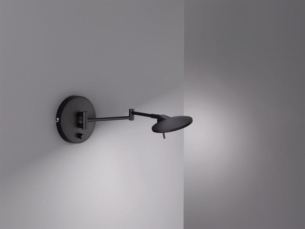 Kinkiet LED 1-punktowy w kolorze czarnym z okrągłą podstawą i ruchomym ramieniem. Lampa o dyskretnym designie, zamontowana na ścianie, emitująca światło w kierunku podłoża. Idealna do nowoczesnych wnętrz.