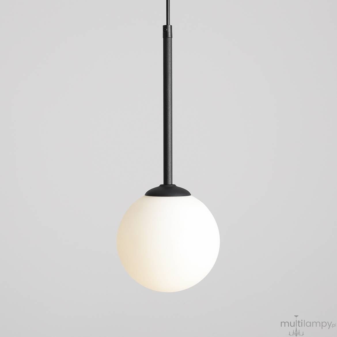 Lampa wisząca Bosso D14, 1-punktowa, z czarnym metalowym uchwytem i białym, okrągłym kloszem. Zawieszona na cienkim kablu, prezentuje minimalistyczny design. Tło jasnoszare, co podkreśla elegancki charakter lampy.