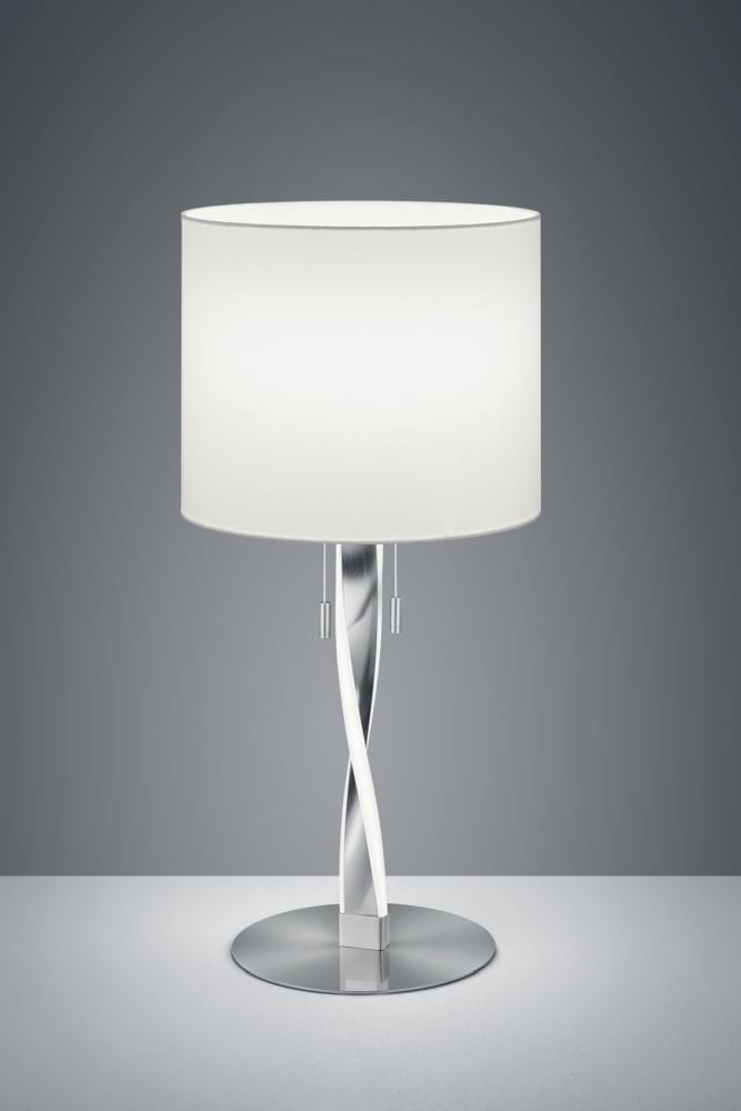 Lampa stołowa Nandor E27 w kolorze niklowym, z białym abażurem. Posiada nowoczesny, spiralny stelaż oraz dwa metalowe przełączniki. Ustawiona na okrągłej podstawie, na jednolitym tle. Idealna do wnętrz nowoczesnych.
