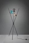 Lance lampa podłogowa 3-punktowa w kolorze czarnym z trzema szklanymi kloszami: niebieskim, szarym i żółtym. Stojąca konstrukcja z metalowymi nogami w kształcie litery V, z widocznym przewodem zasilającym na podłodze.