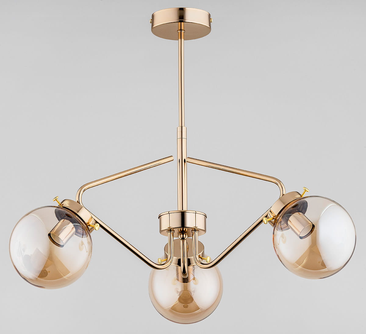 Złota lampa wisząca Barsum 3-punktowa z trzema przezroczystymi kloszami. Ujęcie z dołu, pokazujące finezyjny kształt i połączenie elementów metalowych z szklanymi. Elegancka konstrukcja z wyraźnymi detalami, montowana na suficie.