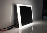 Evo Black LED oprawa schodowa 230V z neutralnym światłem 4000K, kwadratowa, z czarnym wnętrzem i białą ramką. Ujęcie z boku, widoczne przewody zasilające. Produkt w pozycji stojącej na gładkiej powierzchni.