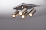Lampa sufitowa Marley 4-punktowa w kolorze niklu, z czterema cylindrycznymi reflektorami zamontowanymi na kwadratowej podstawie. Reflektory skierowane w różne strony, emitujące ciepłe światło, zamontowane na białym suficie.