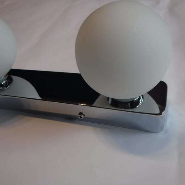 Brazos kinkiet 3-punktowy z chromowaną podstawą i trzema matowymi kulkami. Produkt widoczny z boku, z wyraźnymi detalami chromu oraz kształtów kul. Idealny do nowoczesnych wnętrz.