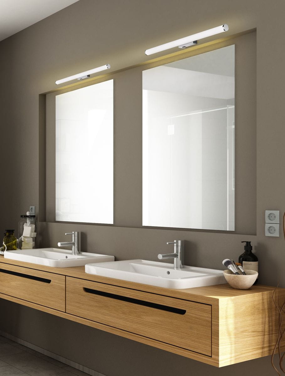Kinkiet Mattimo LED IP44 w kolorze chromu, długość 60 cm, moc 6,5W, zamontowany nad dwoma umywalkami w nowoczesnej łazience. Oświetlenie w minimalistycznym stylu, idealne do przestrzeni z lustrami. Tło w neutralnym odcieniu.