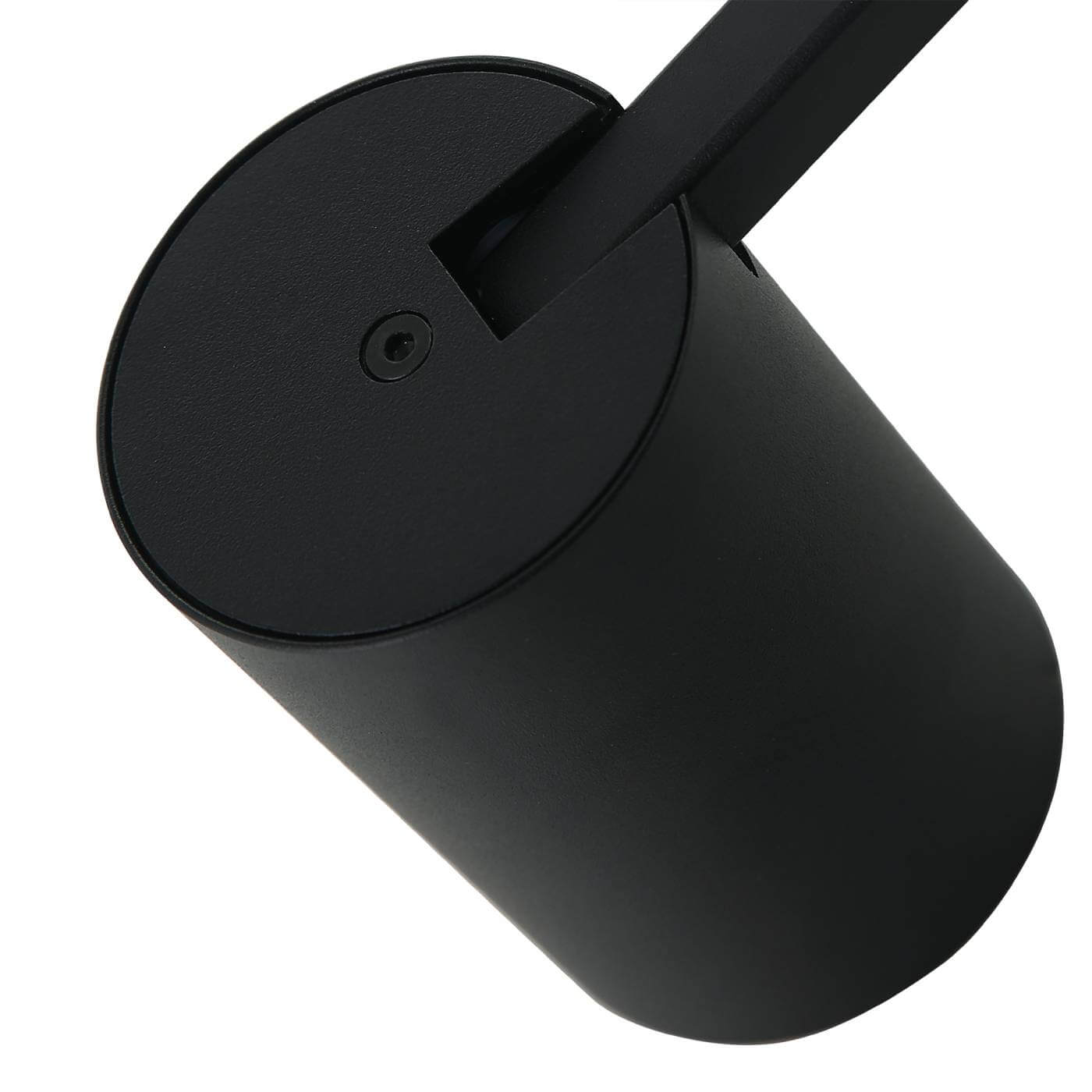 Czarna lampa sufitowa Tuka Nero L w formie jednopunktowego spotu. Widok z góry, ukazujący okrągłą podstawę oraz zamocowanie w postaci cienkiego ramienia. Gładka, matowa powierzchnia bez dodatkowych zdobień.
