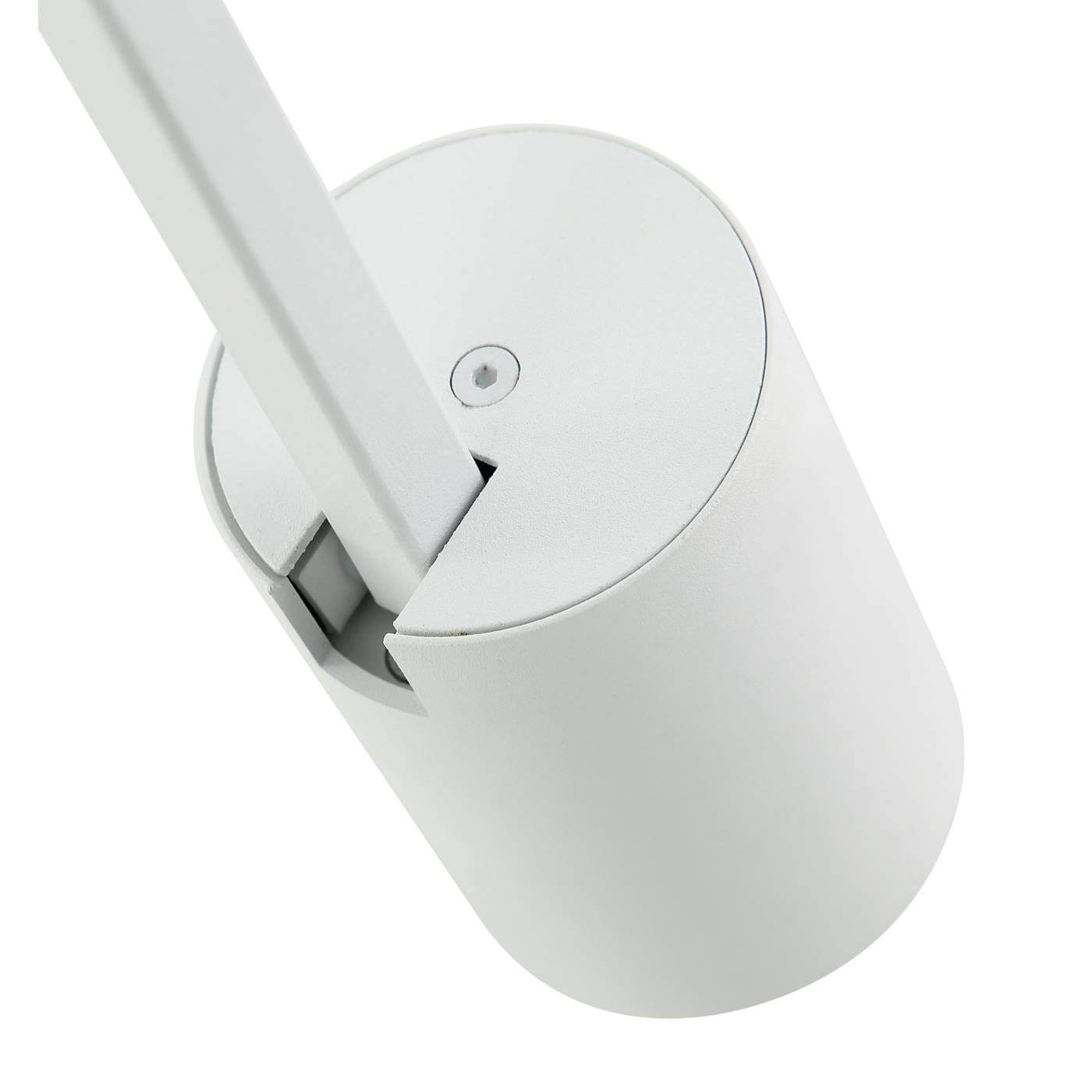 Lampa sufitowa Tuka Bianco L w kolorze białym, jednopunktowa, z cylindryczną podstawą i prostokątnym uchwytem. Ujęcie z góry, ukazujące detale mocowania. Faktura matowa, nowoczesny design. Idealna do oświetlenia wnętrz.