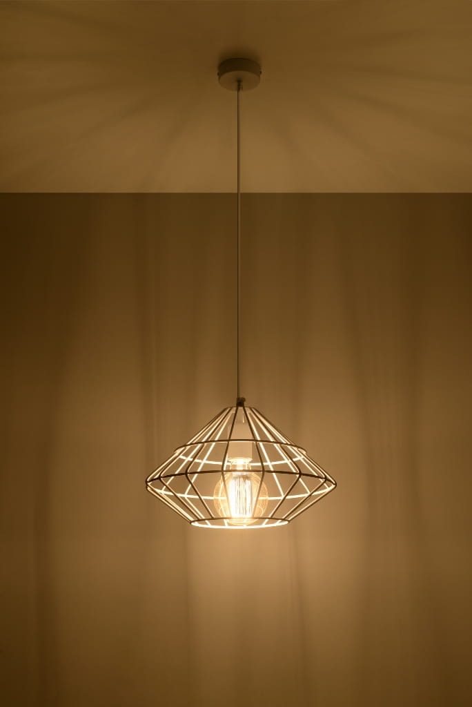 Lampa wisząca Umberto 1-punktowa w kolorze białym, o geometrycznym kształcie w formie diamentu. Wisi na cienkim sznurku, z widoczną żarówką w środku, emitując ciepłe światło na tle jednolitej, jasnej ściany.