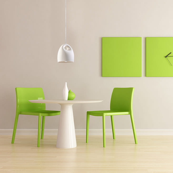 Lampa wisząca Bukano SL.0842 w kształcie ceramicznego klosza, biały kolor, zawieszona nad okrągłym, białym stołem. W tle zielone krzesła i dekoracje na ścianie w odcieniach zieleni. Eleganckie, nowoczesne wnętrze.