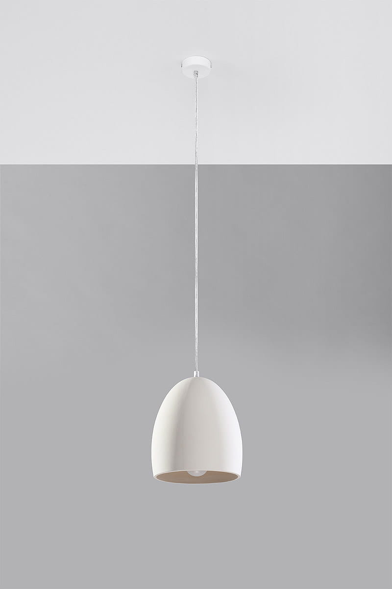 Lampa wisząca Flawiusz 1-punktowa, ceramiczna, w kształcie stożka, w kolorze białym, z metalowym mocowaniem. Zawieszona na cienkim, białym przewodzie, z widoczną żarówką wewnątrz. Tło szare, podkreślające minimalistyczny design.
