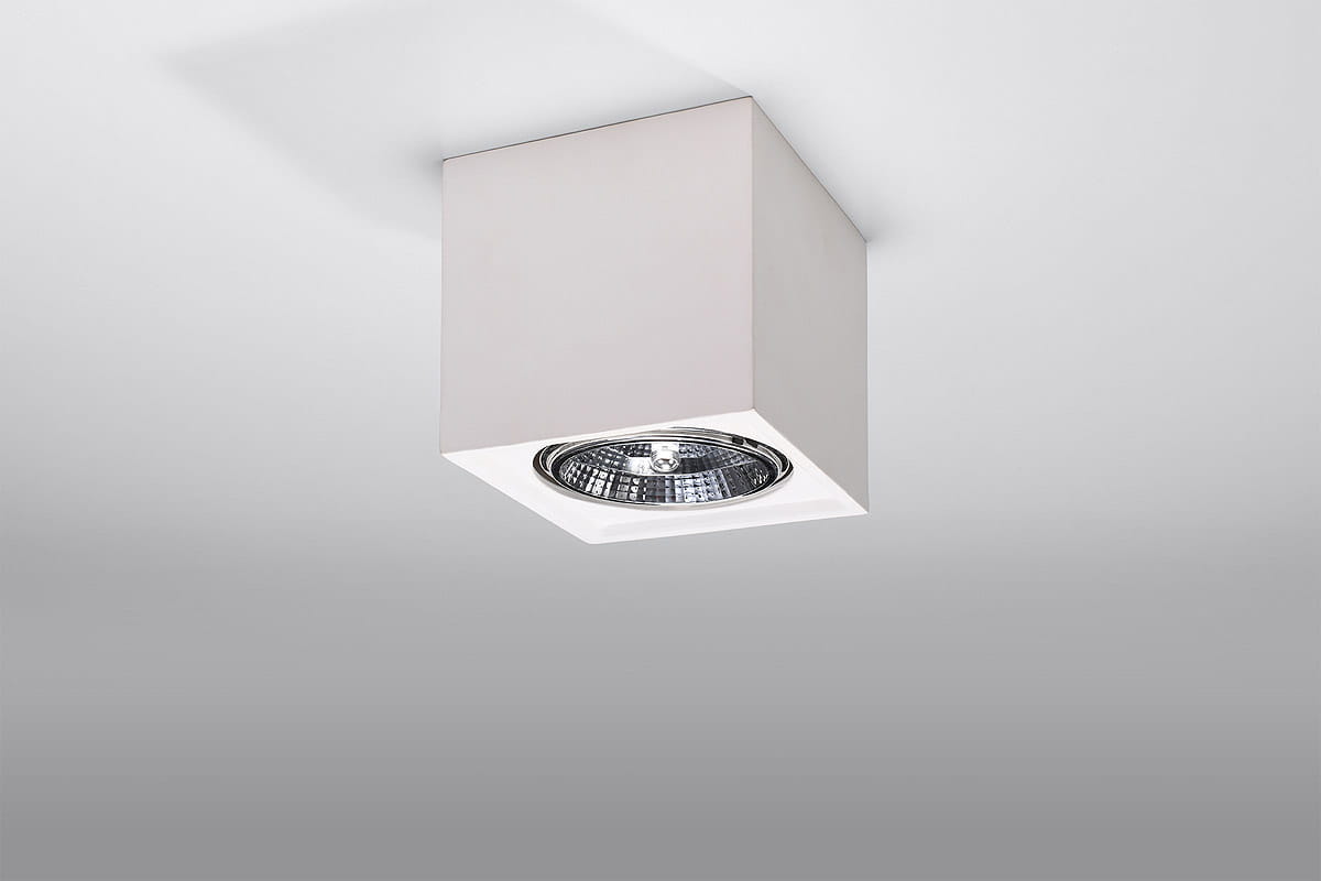 Lampa sufitowa Seida 1-punktowa, ceramiczna, w kolorze białym. Kwadratowa obudowa z wykończeniem matowym, z widocznym reflektorem w środku. Montowana na suficie, w perspektywie frontalnej. Idealna do nowoczesnych wnętrz.