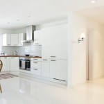 Kinkiet Lee 1-punktowy ML6383 w chromowanej oprawie z białym kloszem, zamontowany na ścianie w kuchni. Produkt o nowoczesnym designie, umieszczony obok jasnych, minimalistycznych mebli kuchennych.