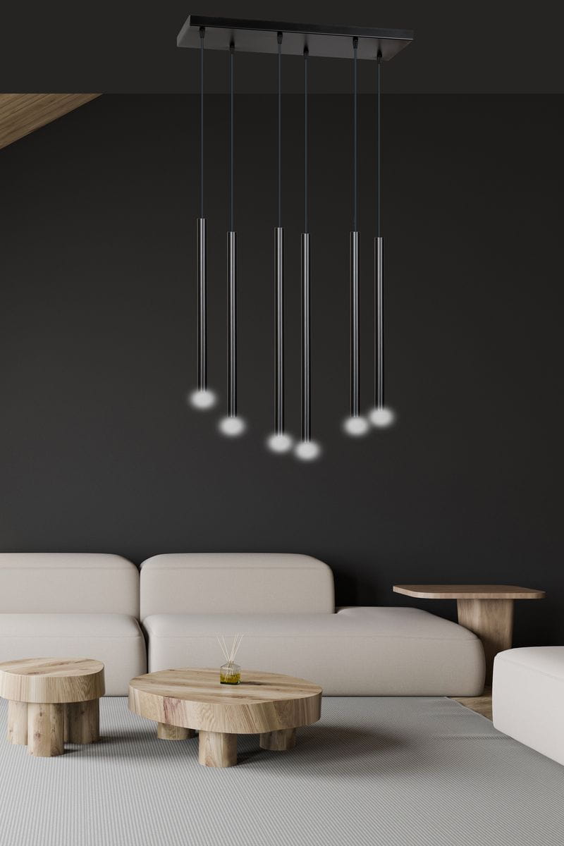 Lampa wisząca Selter 6-punktowa w kolorze czarnym, składająca się z sześciu cienkich, podłużnych opraw z białymi kloszami. Zawieszona na prostokątnej podstawie, umiejscowiona nad jasnymi meblami w nowoczesnym wnętrzu.