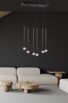 Lampa wisząca Selter 6-punktowa w kolorze czarnym, składająca się z sześciu cienkich, podłużnych opraw z białymi kloszami. Zawieszona na prostokątnej podstawie, umiejscowiona nad jasnymi meblami w nowoczesnym wnętrzu.