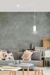 Lampa wisząca 1-punktowa Traker w kolorze białym, zawieszona na długim, prostym przewodzie. Produkt umieszczony w nowoczesnym wnętrzu z szarymi ścianami, obok sofy z poduszkami i stolików.