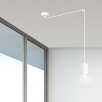 Lampa wisząca Traker 1-punktowa w kolorze białym, zawieszona na cienkim, prostym przewodzie. Posiada cylindryczny klosz, emitujący światło w dół, umieszczony na długim ramieniu przymocowanym do sufitu. Tło jasne, minimalistyczne.