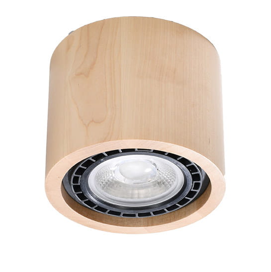 Lampa sufitowa 1-punktowa w kształcie cylindrycznym, wykonana z jasnego drewna. Na końcu znajduje się okrągła oprawa z przezroczystą żarówką. Produkt zamontowany w pozycji wiszącej, z widocznym czarnym elementem mocującym.