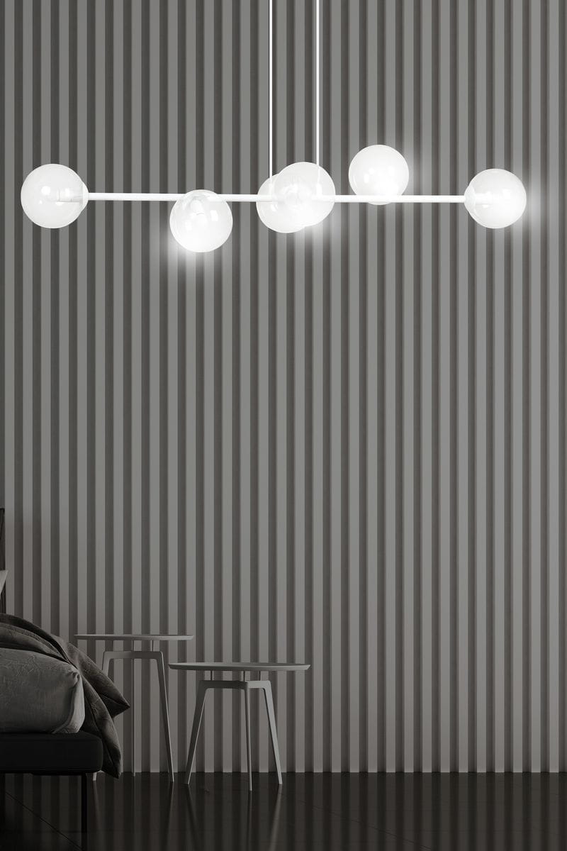 Lampa wisząca Rossi 6-punktowa w białym i transparentnym kolorze, z okrągłymi kloszami. Zawieszona na cienkim, białym stelażu. Widok frontalny, z tłem w paski. Idealna do nowoczesnych wnętrz.