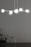 Lampa wisząca Rossi 6-punktowa w białym i transparentnym kolorze, z okrągłymi kloszami. Zawieszona na cienkim, białym stelażu. Widok frontalny, z tłem w paski. Idealna do nowoczesnych wnętrz.