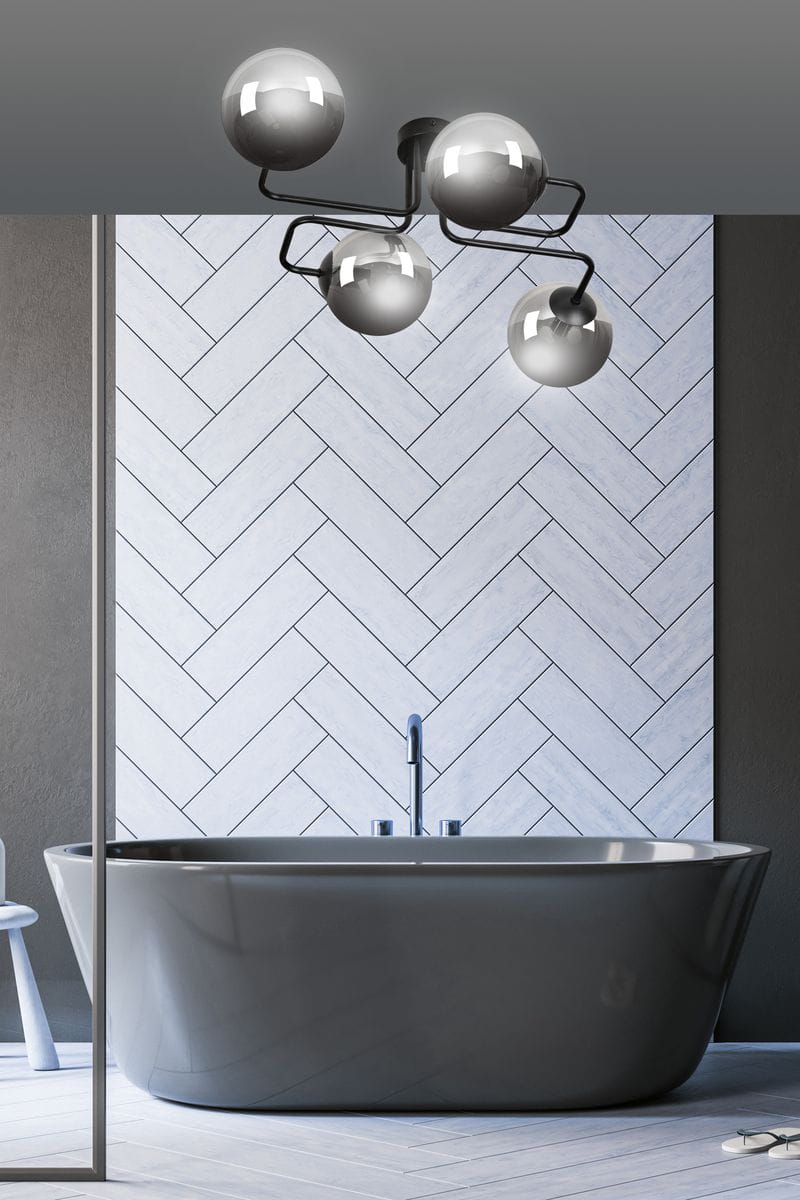 Grafitowa lampa sufitowa 4-punktowa Brendi z błyszczącymi, okrągłymi kloszami, zamontowana na skomplikowanej konstrukcji metalowej. Ujęcie z góry w nowoczesnej łazience z wanną, na tle jasnej, wzorzystej ściany.