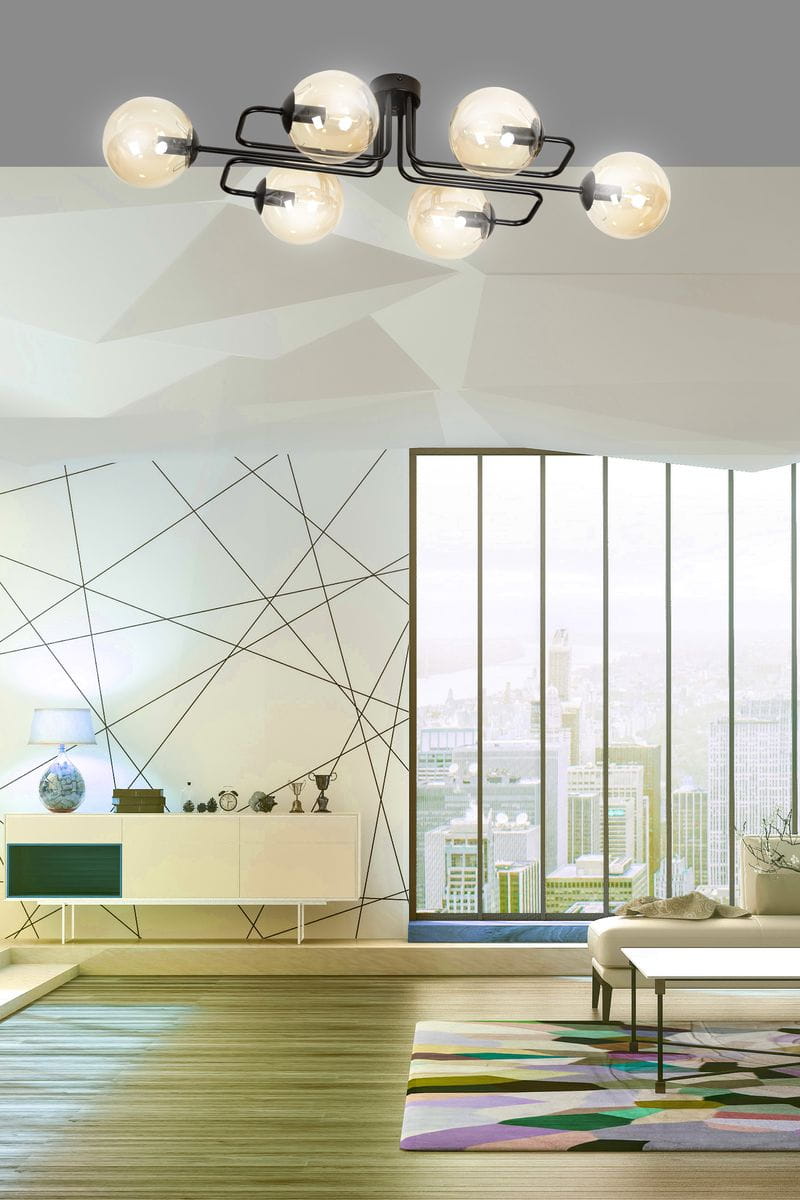 Lampa sufitowa Brendi A, 6-punktowa, w kolorze miodowym. Konstrukcja z czarnym wykończeniem, z sześcioma przezroczystymi kloszami w kształcie kul. Zawieszona na suficie w nowoczesnym wnętrzu z dużymi oknami i minimalistycznym wystrojem.