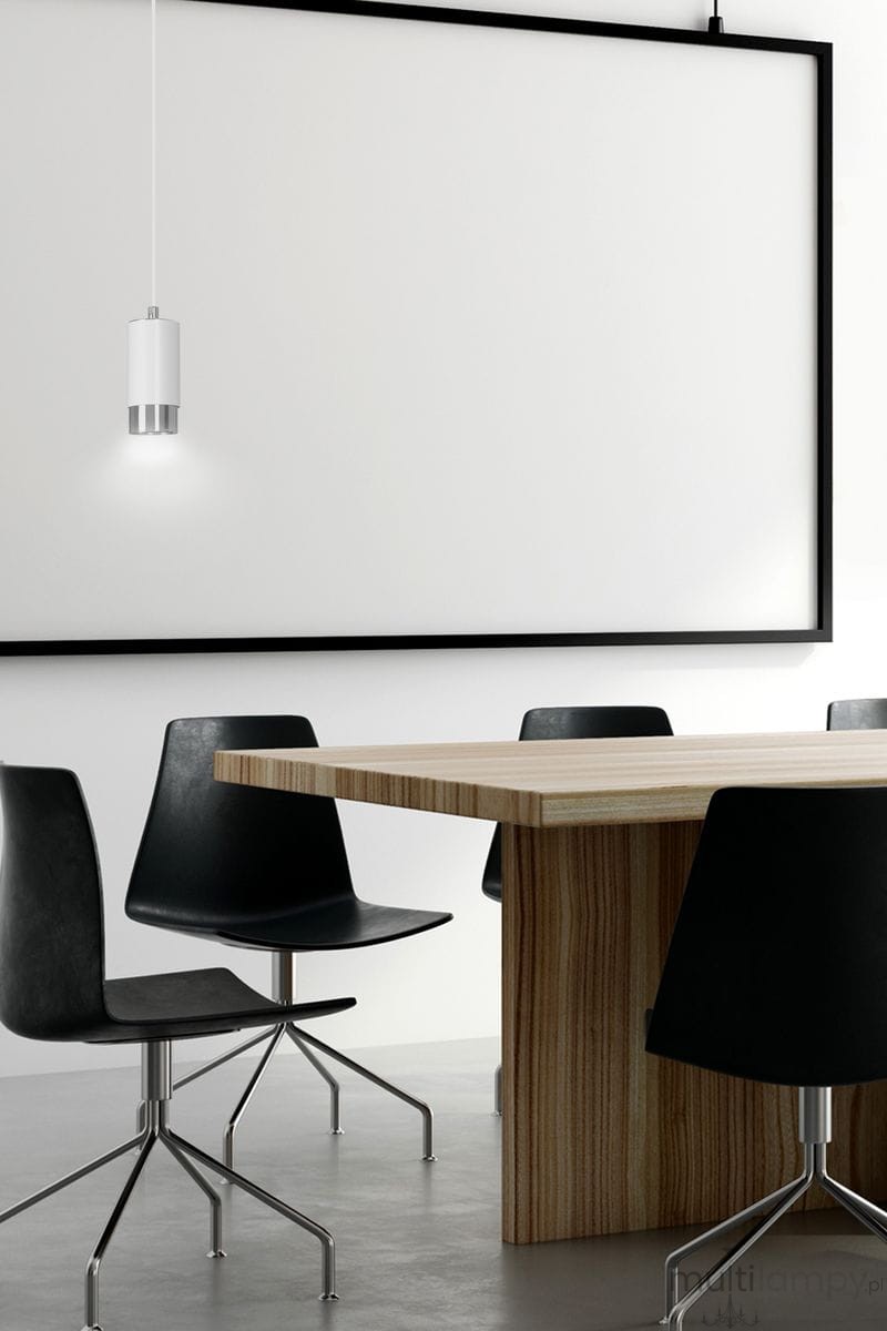 Lampa wisząca Fumiko 1-punktowa w kolorze białym z chromowanym wykończeniem, zawieszona nad prostokątnym stołem, z czterema czarnymi krzesłami w tle. Produkt ma cylindryczny kształt z metalowym akcentem u dołu, emitującym miękkie światło.