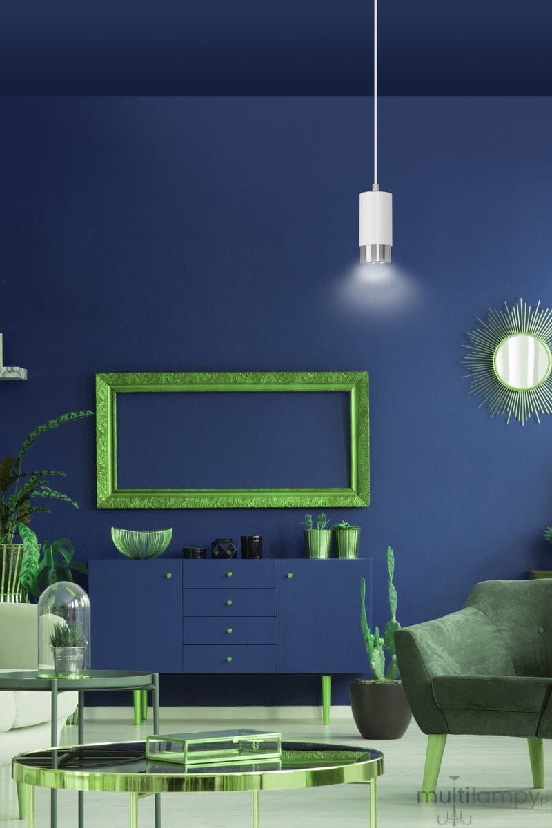 Lampa wisząca Fumiko 1-punktowa w białym kolorze z chromowanymi detalami, zawieszona na cienkim przewodzie, emituje światło w nowoczesnym wnętrzu. Tło w intensywnym granacie z zielonymi akcentami mebli i roślinami.