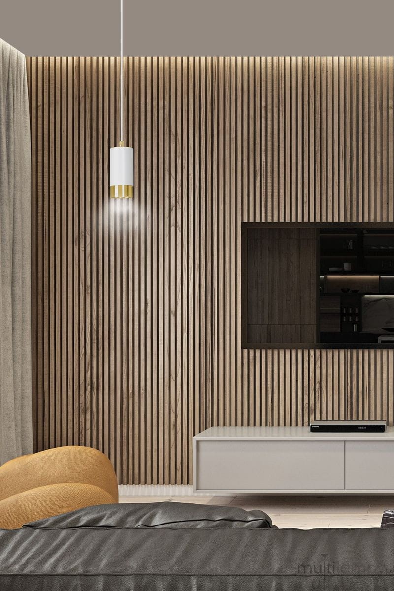 Lampa wisząca Fumiko 1-punktowa w białym kolorze z złotym wykończeniem, zawieszona na cienkim kablu, umiejscowiona nad nowoczesnym meblem w salonie o drewnianej ścianie. Otoczenie z szarym tłem, podkreślające elegancki design lampy.