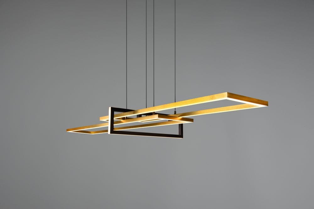 Trójpunktowa lampa wisząca Salinas w kolorze mosiądzu i czerni, składająca się z trzech prostokątnych ram, zawieszona na cienkich linkach. Lampa ma nowoczesny design, z matowym wykończeniem i LED-owym oświetleniem.