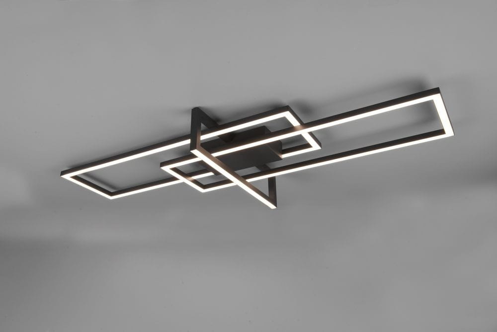 Czarna lampa sufitowa Salinas LED 3-punktowa z geometrycznym kształtem, składająca się z trzech prostokątnych ram, zamontowana na suficie. Świecąca ledowa krawędź zapewnia nowoczesne oświetlenie. Tło jasne, proste.