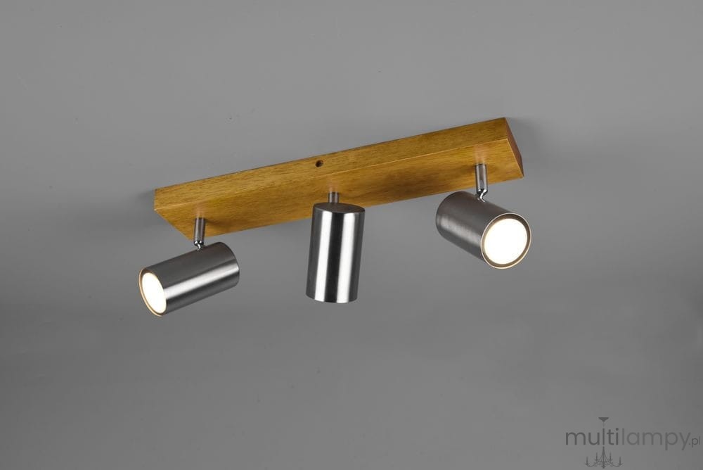 Lampa sufitowa Marley 3-punktowa z drewnianą podstawą w kolorze jasnego brązu i trzema metalowymi reflektorami w kolorze niklu. Reflektory są cylindryczne, montowane na ruchomej podstawie. Ujęcie z góry, na jednolitym szarym tle.