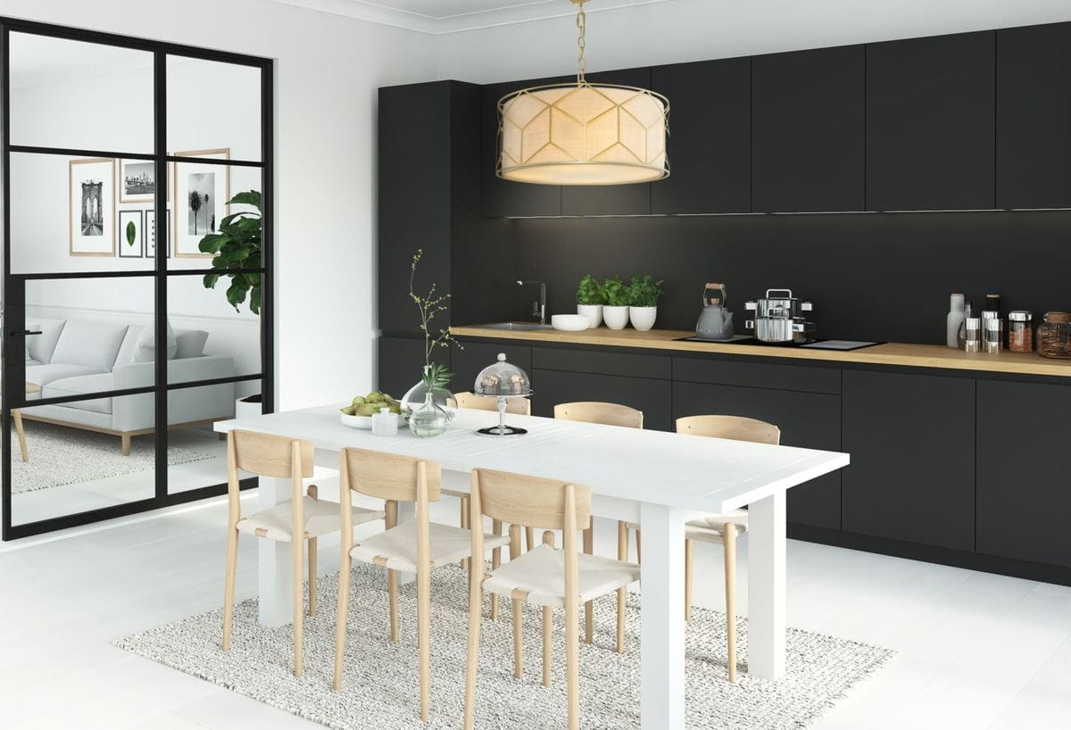 Lampa wisząca Messina 4-punktowa H223PL-03G w kształcie cylindrycznym, z jasnobeżowym abażurem, zawieszona nad białym stołem w jadalni. Tło kuchenne w odcieniach czerni z drewnianym blatem i roślinami. Pozycja centralna, widok z boku.